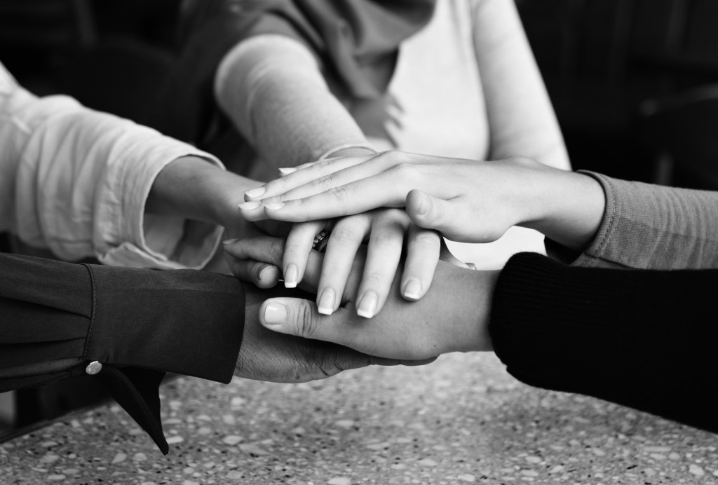 Different people with hands in a pile. Team spirit. 